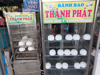 two food stands with one half filled with real edible baozi and the other filled with fake plastic ones